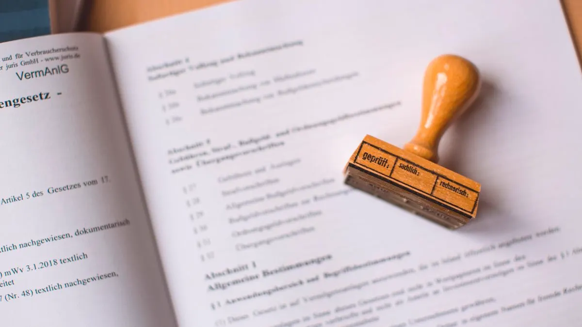 Ein Stempel liegt auf einem aufgeschlagenen Gesetzestext