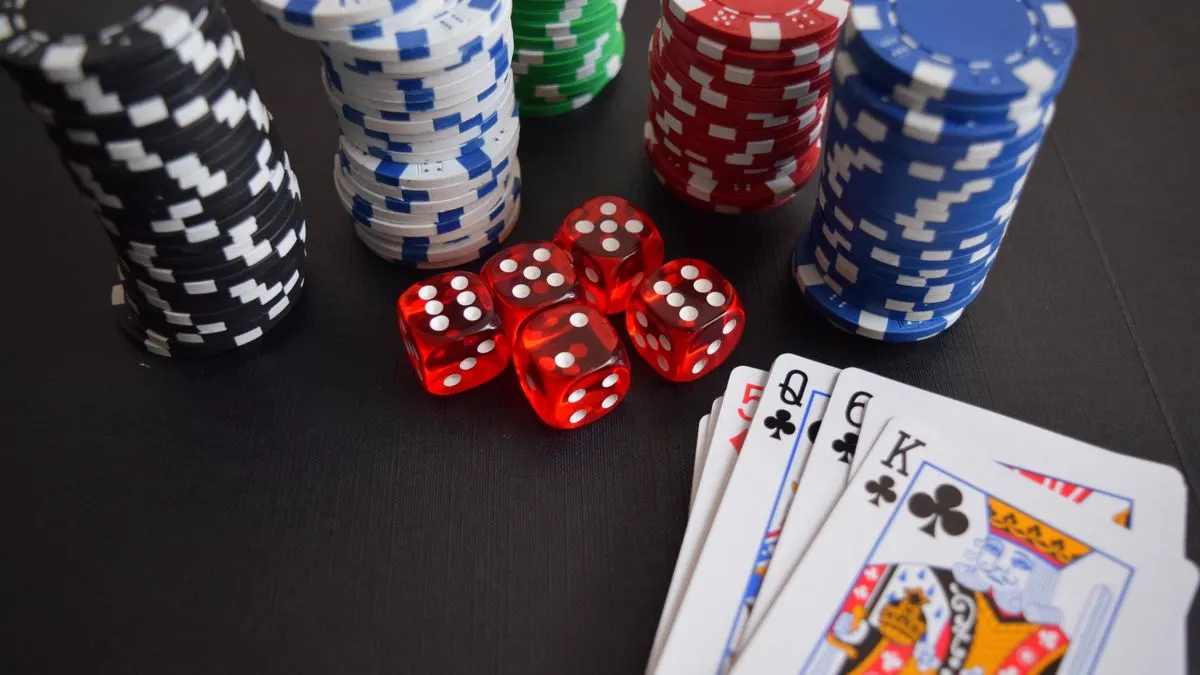 Casinosjetonger, terninger og spillkort på et bord